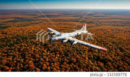 Vintage Bomber Aircraft Soaring Above Autumn Forest Canopy Bathed In Sunlight 132389778
