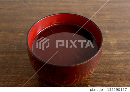 テーブル背景の汁椀に入った具が無いおしるこ 132390127