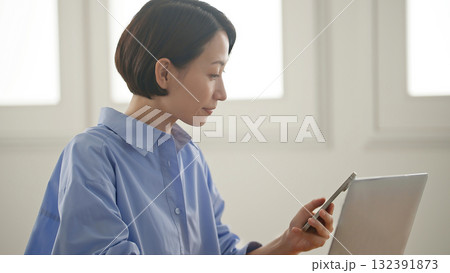 パソコンをする女性(携帯操作) 132391873