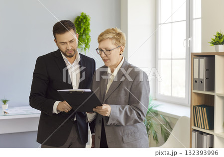 Business colleagues discussing planning and strategy with clipboard in office 132393996