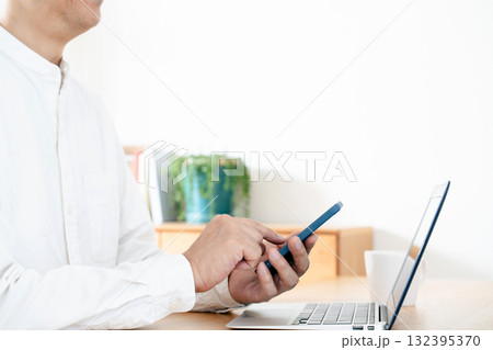 スマホを操作する男性の手元 132395370