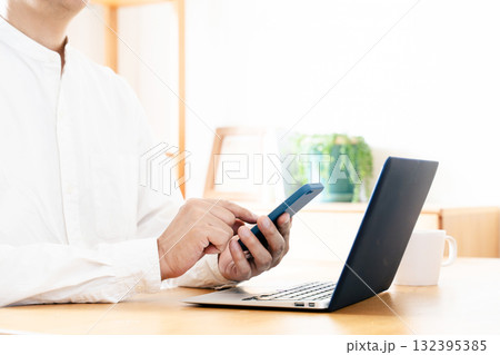 スマホを操作する男性の手元 132395385