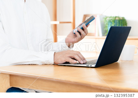 スマホを操作する男性の手元 132395387