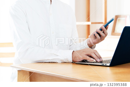スマホを操作する男性の手元 132395388
