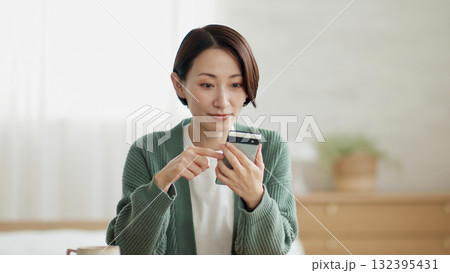 携帯を操作している女性 132395431