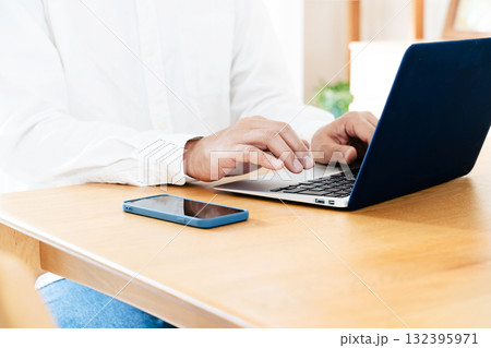 スマホを操作する男性の手元 132395971