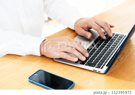 スマホを操作する男性の手元 132395972