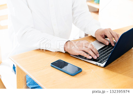 スマホを操作する男性の手元 132395974