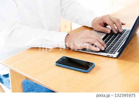 スマホを操作する男性の手元 132395975