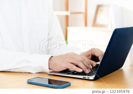 スマホを操作する男性の手元 132395976