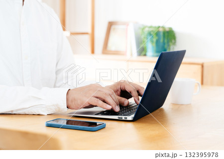 スマホを操作する男性の手元 132395978