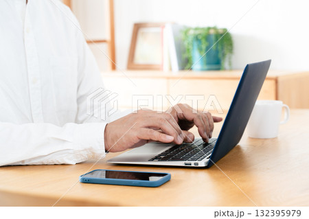 スマホを操作する男性の手元 132395979