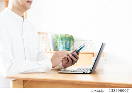 スマホを操作する男性の手元 132396007