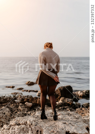 Woman Ocean Rocks Seashore: Contemplative autumnal coastal scene. 132397332