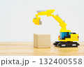 おもちゃのショベルカーが木のブロックを持ち上げる作業風景 132400558