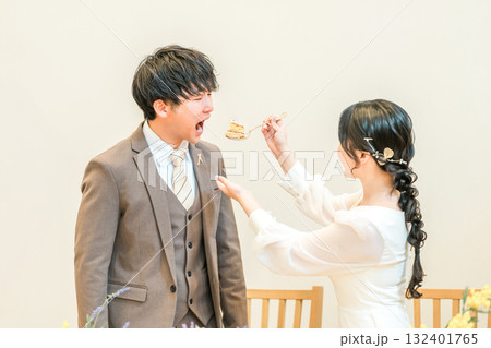 結婚式でファーストバイトをする新郎新婦(ウェディングケーキ・ケーキ入刀) 132401765
