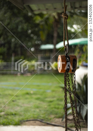 Small Pulley Hanging Outside The House, Small pulley hangs elegantly outside a rustic house, showcasing durability, perfect for promoting outdoor tool solutions. 132402006