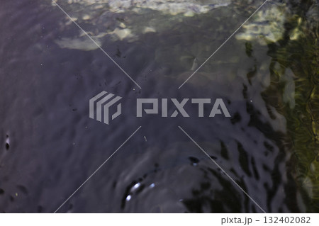 Ripples On Water Surface In Basin, Gentle ripples dance on a water surface in a basin, light reflecting off each wave, perfect for a nature photography shot or a serene water showcase. 132402082