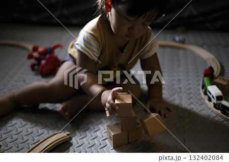 Toddler Playing With Wooden Toys A curious toddler explores wooden toys with a big smile, great for family lifestyle marketing images. 132402084