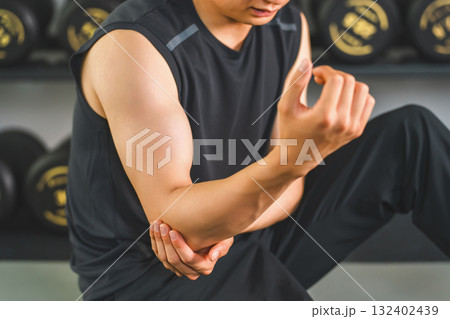 ジムでトレーニング中に肘を痛がる若いアジア人男性 ジムでトレーニング中に肘を痛がる若いアジア人男性 132402439
