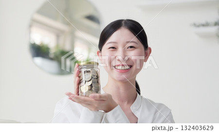 笑顔でお金が入った瓶を持つアジア人女性 132403629