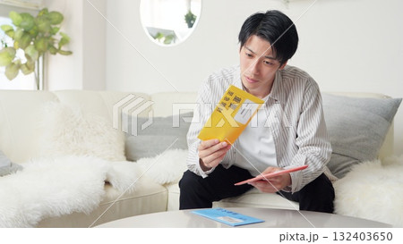 督促状を確認するアジア人男性 132403650