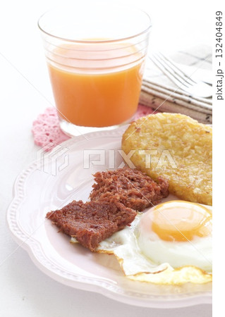 目玉焼きとハッシュドポテトとコンビーフの朝食プレートとキャロットジュース 目玉焼きとハッシュドポテトとコンビーフの朝食プレートとキャロットジュース 132404849