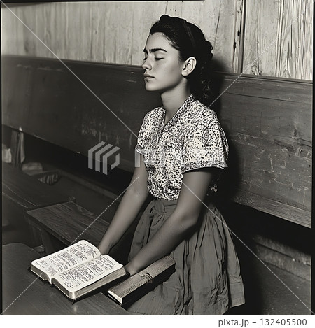 Young woman sits in a classroom with her hands on her knees Young woman sits in a classroom with her hands on her knees 132405500