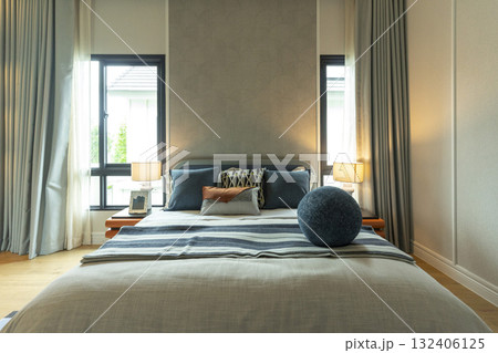 Interior view of modern bedroom with blue and yellow pillow on bed. 132406125