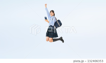 スマホを持ってジャンプする制服の女子学生の全身写真 スマホを持ってジャンプする制服の女子学生の全身写真 132406353