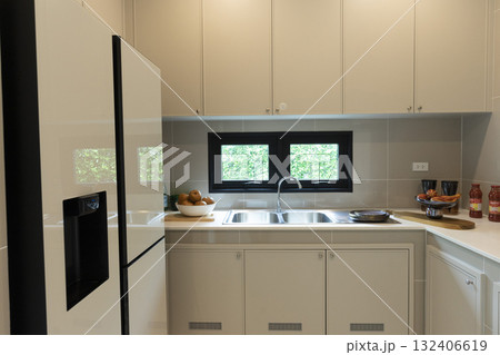 Interior view of home kitchen with refrigerator and window. Interior view of home kitchen with refrigerator and window. 132406619
