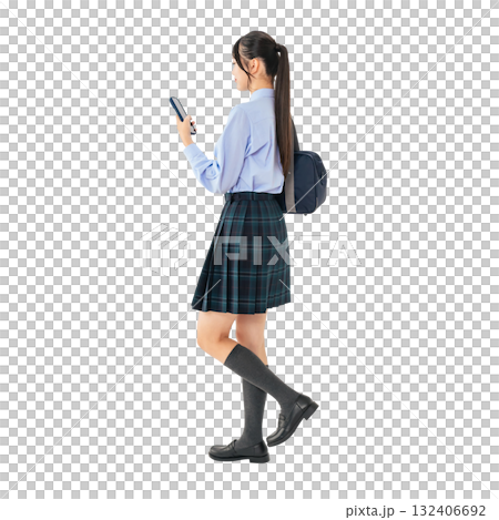 スマホを見ながら歩く制服の女子学生　手作業で精密に切り抜いた背景透過全身写真PNG 132406692
