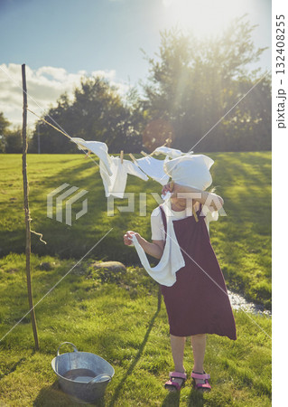 Charming girl washing clothes in the garden. Retro portrait 132408255