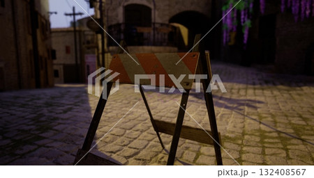 A construction barrier stands prominently on a cobblestone street in an ancient town. The buildings and dimming light create a serene atmosphere during the evening. A construction barrier stands prominently on a cobblestone street in an ancient town. The buildings and dimming light create a serene atmosphere during the evening. 132408567