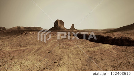 A vast desert terrain features rugged rock formations against a muted, hazy sky. The dry environment highlights the arid conditions and geological features present in the area. A vast desert terrain features rugged rock formations against a muted, hazy sky. The dry environment highlights the arid conditions and geological features present in the area. 132408619