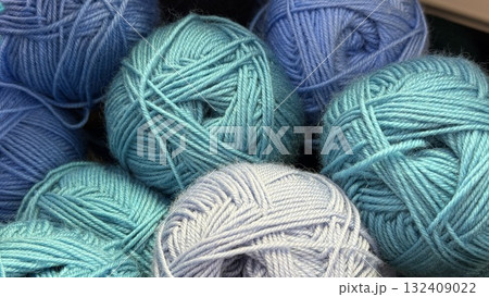 Blue and teal yarn balls in various shades stacked closely, useful for craft and textile backgrounds Blue and teal yarn balls in various shades stacked closely, useful for craft and textile backgrounds 132409022