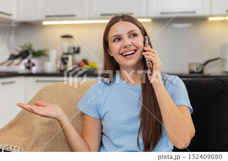 Young woman enjoys smartphone call smiles listens speaks in lively chat friendly voice and warm mood Young woman enjoys smartphone call smiles listens speaks in lively chat friendly voice and warm mood 132409080