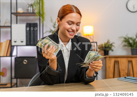 Young businesswoman happily counts dollar income proud of salary bonus and bright financial success 132409145