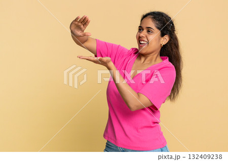 Indian woman joyfully throwing imaginary money in air, celebrating financial success with happiness Indian woman joyfully throwing imaginary money in air, celebrating financial success with happiness 132409238
