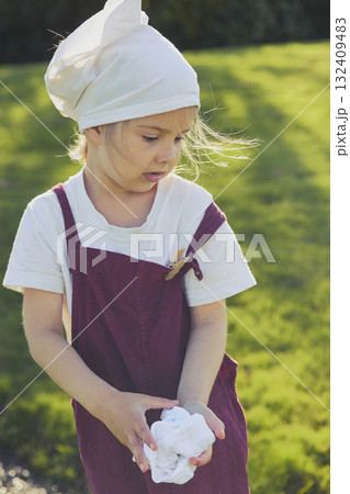 Charming girl washing clothes in the garden. Retro portrait 132409483