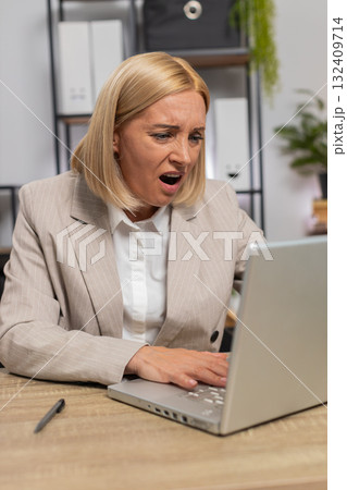 Displeased sad businesswoman using laptop becoming surprised lottery results bad news computer virus 132409714