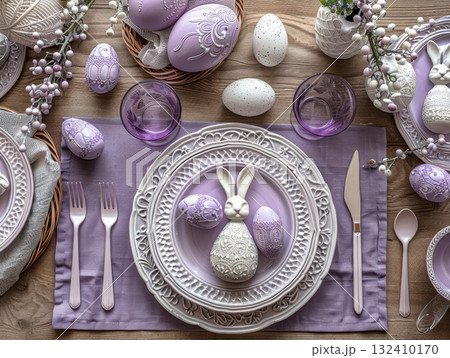 Elegant Easter table setting featuring purple white theme, decorative bunny rabbit centerpiece matching plate. Table adorned with eggs, cutlery, glassware, creating festive atmosphere 132410170
