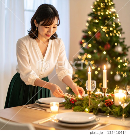 クリスマスディナーのテーブルを整える日本人女性の温かな冬のポートレート クリスマスディナーのテーブルを整える日本人女性の温かな冬のポートレート 132410414