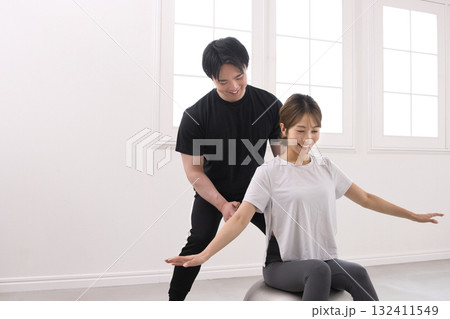 パーソナルトレーナーにトレーニングを受ける若い女性 132411549