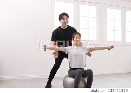 パーソナルトレーナーにトレーニングを受ける若い女性 132411550