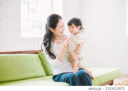 リビングで赤ちゃんを抱くおばあちゃん リビングで赤ちゃんを抱くおばあちゃん 132412972