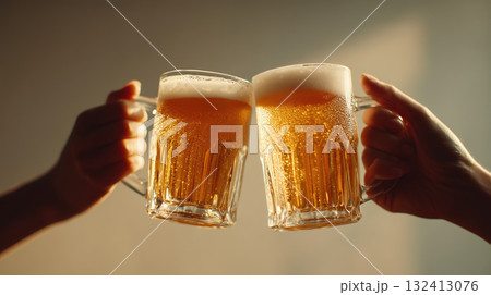 Two hands clinking beer mugs with foam heads 132413076