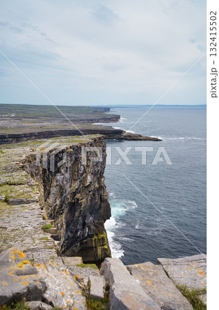 Dramatic coastal cliffs of Ireland overlooking the ocean under a cloudy sky. Dramatic coastal cliffs of Ireland overlooking the ocean under a cloudy sky. 132415502