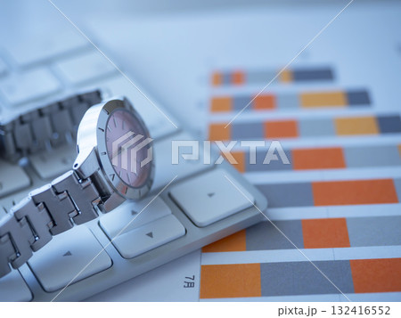 テーブルに置かれたグラフとキーボードと腕時計 テーブルに置かれたグラフとキーボードと腕時計 132416552