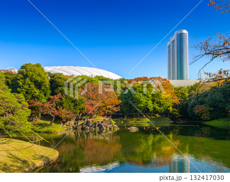 伝統的な日本庭園の紅葉と近代的な高層ビルやドーム球場 (東京都、文京区、小石川後楽園) 伝統的な日本庭園の紅葉と近代的な高層ビルやドーム球場 (東京都、文京区、小石川後楽園) 132417030